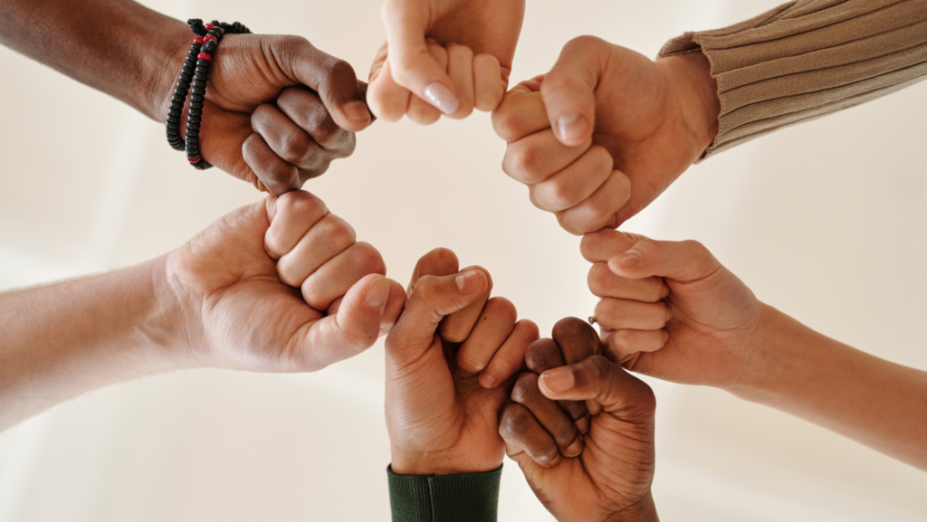 A group of diverse people joining hands, symbolizing community connection.